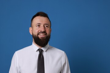 Handsome bearded man in formal outfit on blue background. Space for text