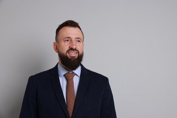 Handsome bearded man in suit on grey background. Space for text