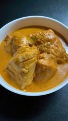 Delicious looking chicken pieces served in creamy orange sauce in a bowl