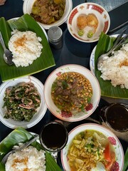 Several different plates of various asian meals with rice
