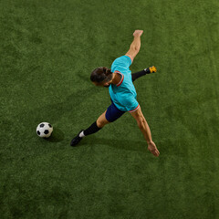 Dynamic overhead shot of footballer maneuvering for game-changing kick, posture controlled, eyes...
