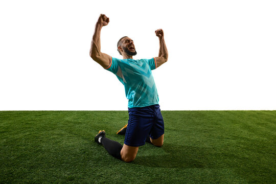 Passionate footballer celebrating victory, kneeling on grass, fists clenched, roaring in triumph, emotions pouring after decisive match. Concept of glory, dedication, competition, final goal, success.
