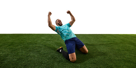 Male footballer celebrating victory, kneeling on grass, fists clenched, roaring in triumph,...
