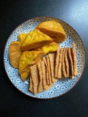 An overhead image of various fried food on a patterned plate