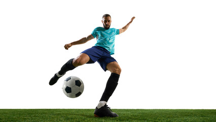 Forward view football player striking ball with full power, showing intensity in expression,...