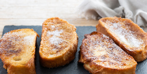 Traditional Spanish torrijas for Holy Week on wooden table.