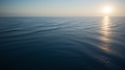 Obraz premium Rippling ocean waves reflect the warm colors of a peaceful sunset.