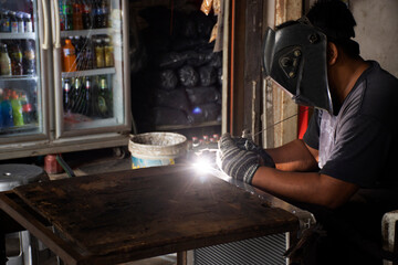 Thai men technician professional people use electric tungsten inert gas welding machine tool weld...