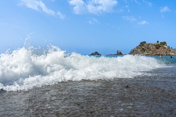 The waves are crashing against the shore with foam