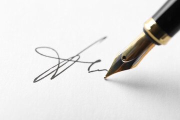 Fountain pen leaving signature on paper, closeup