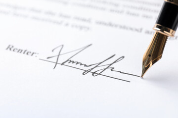 Fountain pen leaving signature on contract, closeup