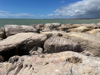 rocks and sea Rocks near the sea, blue sky, and storm clouds in the background
