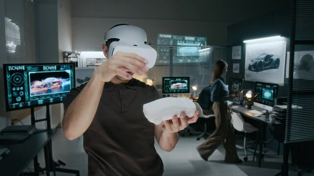 Medium shot of young male automotive engineer wearing augmented reality headset holding clay model of new car, removing and enlarging components while working on vehicle exterior