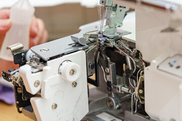 A female mechanic cleans and oils a sewing machine.