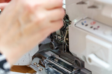 A female mechanic cleans and oils a sewing machine.