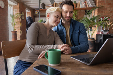 Couple planning their future finances together looking at a laptop