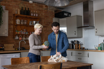 Couple in Kitchen unpacking groceries together