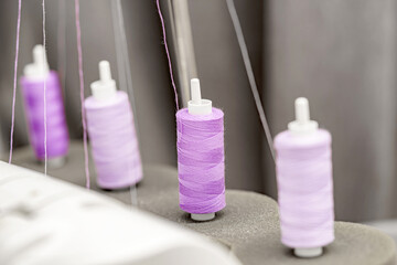 Sewing threads on the overlock machine for sewing. Sewing industry of the textile industry.