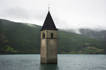 Submerged tower of reschensee church deep in Resias Lake in Bolzano or bozen city at Italy