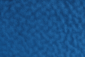 Faux fur, velours blue fabric or cloth with wavy effect. Fluffy fabric of artificial fur textile material texture macro. Canvas background. Decorative fabric for curtain, upholstery and clothes.