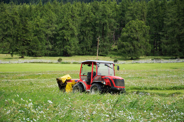 Combine harvesters machinery stop waiting works outdoors at grass field in Trentino-Alto Adige, Italy