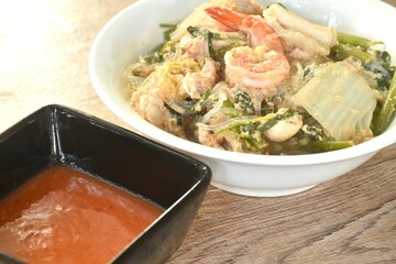 boiled sukiyaki seafood chicken and pork meat couple crispy pickled squid and shrimp with vegetable in soup on bowl dipping sauce