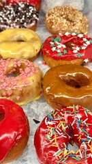 Fresh donuts in the box from the local bakery shop. Mixed freshly baked doughnuts with toppings.