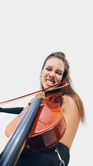 Smiling young woman performing expressively, playing violin against white background. Modern vibe...