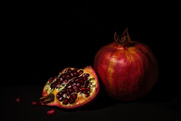 Fresh Pomegranate Fruit Cut Open with Seeds on Dark Background