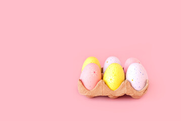 Eco basket with colorful easter eggs on pastel light pink background. minimalistic decoration, minimal composition. Front view, place for text, banner