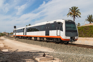 Modern tram train running on railway in suburban area