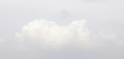 Soft white clouds drift serenely across a light gray, hazy sky, weather, floating