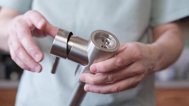 The master demonstrates a new mixer with holes for flexible hoses. Checking the serviceability of a single-valve kitchen faucet.