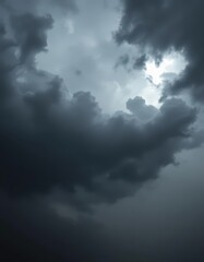 Obraz premium Ominous, brooding storm clouds; dark grey, charcoal, silver linings, heavy rain, atmospheric, moody, dramatic sky, dark grey, intense, silver lining