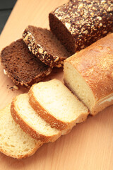 Different bread on plate on light background. Vertical photo