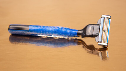 razor cassette on golden background. manual face shaving machine. stubble blade. depilation