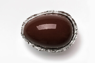 Chocolate egg in foil on white background, chocolate easter egg, top view