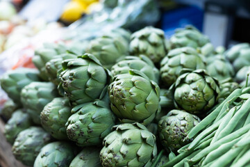 Obraz premium Pile of artichokes displayed on market counter