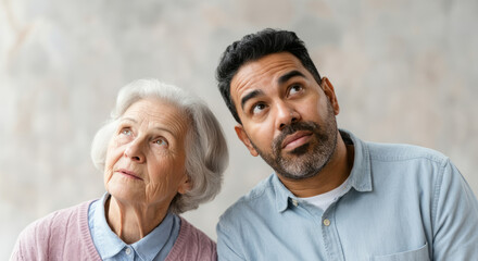 Fototapeta premium Elderly caucasian woman and young hispanic man looking up together