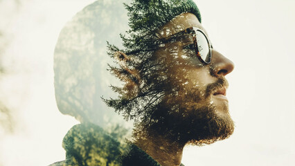 Double exposure of a man blended with a serene forest scene.