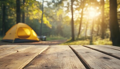 Wooden table in forest with yellow tent under warm sunlight.