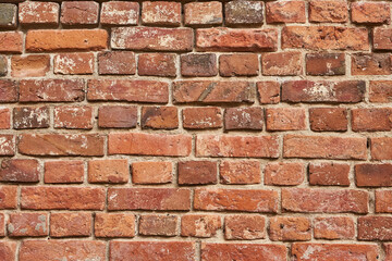 Old red brick wall background, uneven brickwork