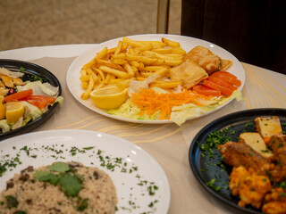 Chef preparing indian food with french fries, vegetables and lemon at the restaurant
