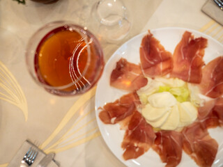 Enjoying italian appetizer with parma ham, mozzarella and wine at the restaurant