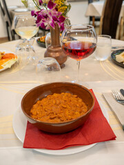 Terracotta bowl of rajma masala with glass of red wine enjoying indian food at restaurant