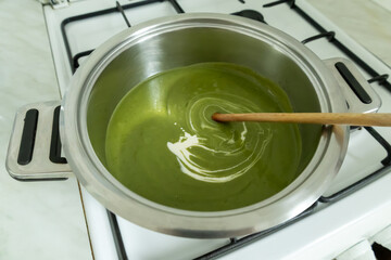 Fototapeta premium Stirring cream into the broccoli cream soup.