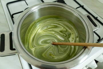 Stirring cream into the broccoli cream soup.