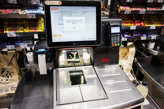 Self checkout machine in a supermarket with products and payment terminal