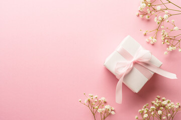 Pink flat lay background. Gift box with white flowers.