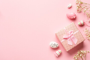 Easter composition on pink background. Easter eggs, flowers, gift box. Flat lay with copy space.